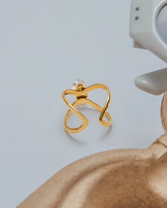 Gold butterfly-shaped earring on a light gray background