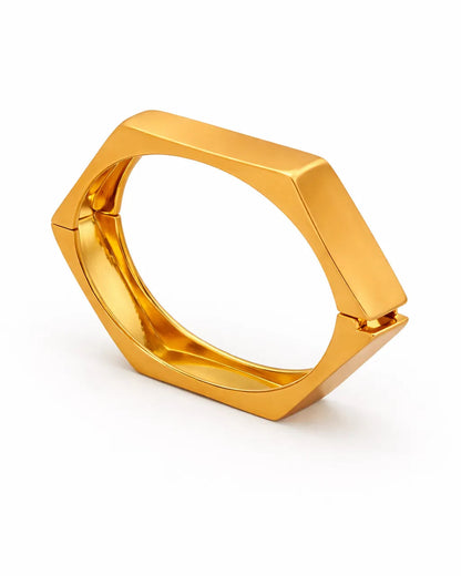 Gold ring with geometric design on a white background