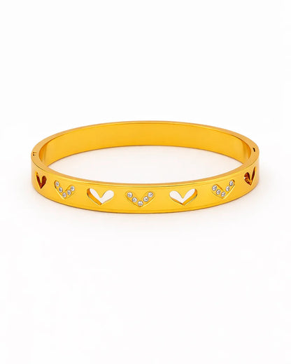 Yellow bracelet with heart and arrow designs on a white background