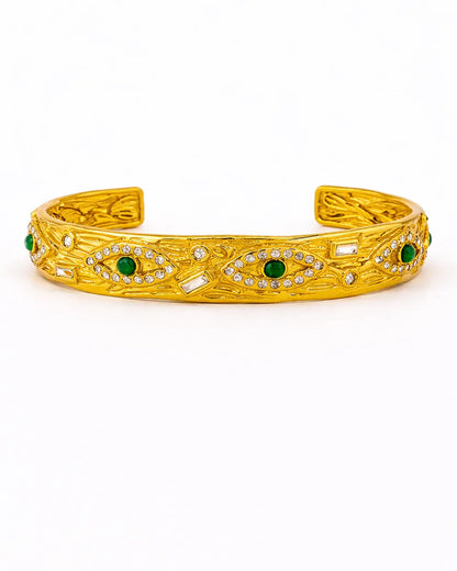 Gold bracelet with green gemstones on a white background