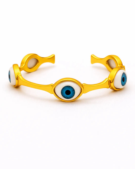 Gold bracelet with eye design on a white background