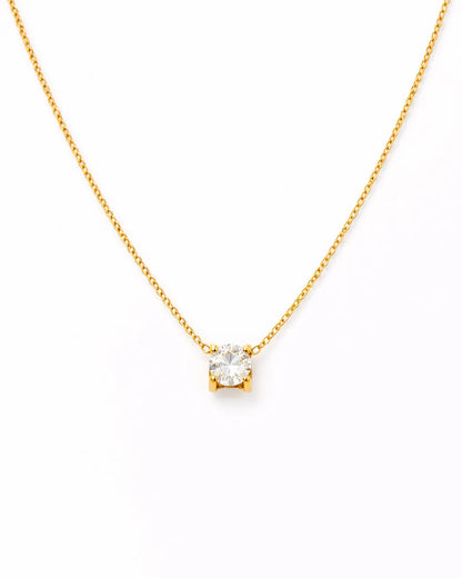 Gold necklace with a small diamond pendant on a white background