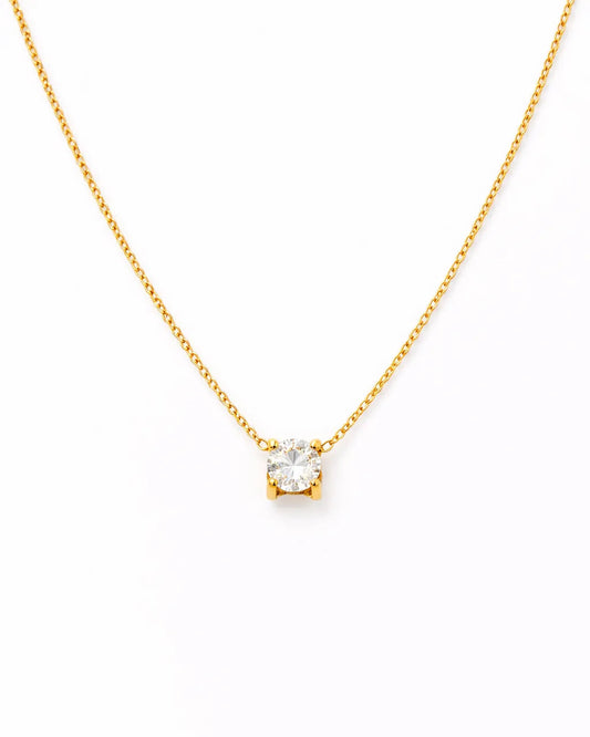 Gold necklace with a small diamond pendant on a white background
