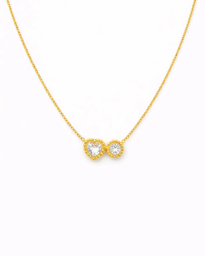 Gold necklace with a heart and infinity symbol pendant on a white background
