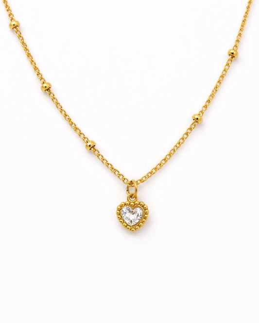 Gold necklace with a heart-shaped pendant on a white background
