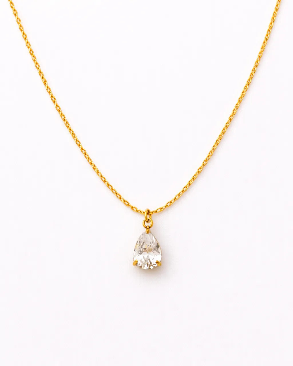 Gold necklace with a teardrop-shaped pearl pendant on a white background