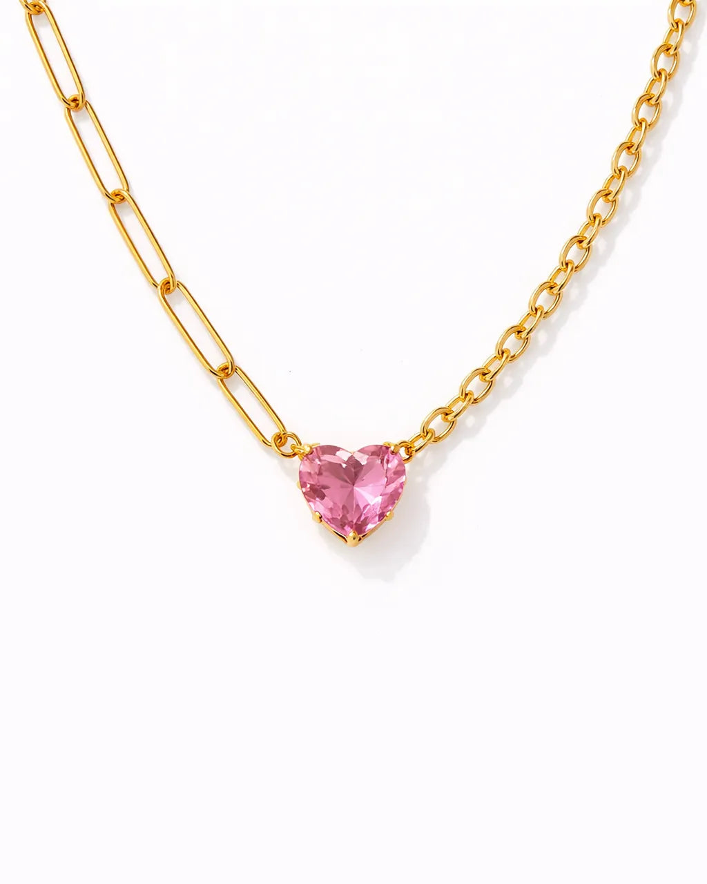 Gold necklace with a pink heart-shaped gemstone on a white background