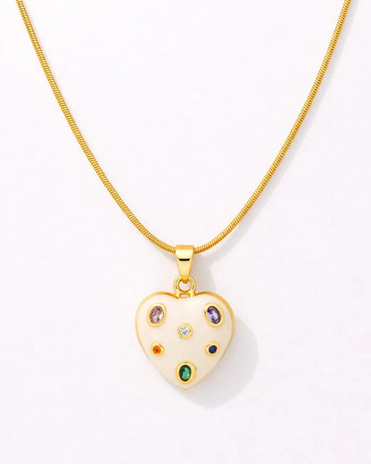 Gold necklace with a heart-shaped pendant featuring colorful gemstones on a white background