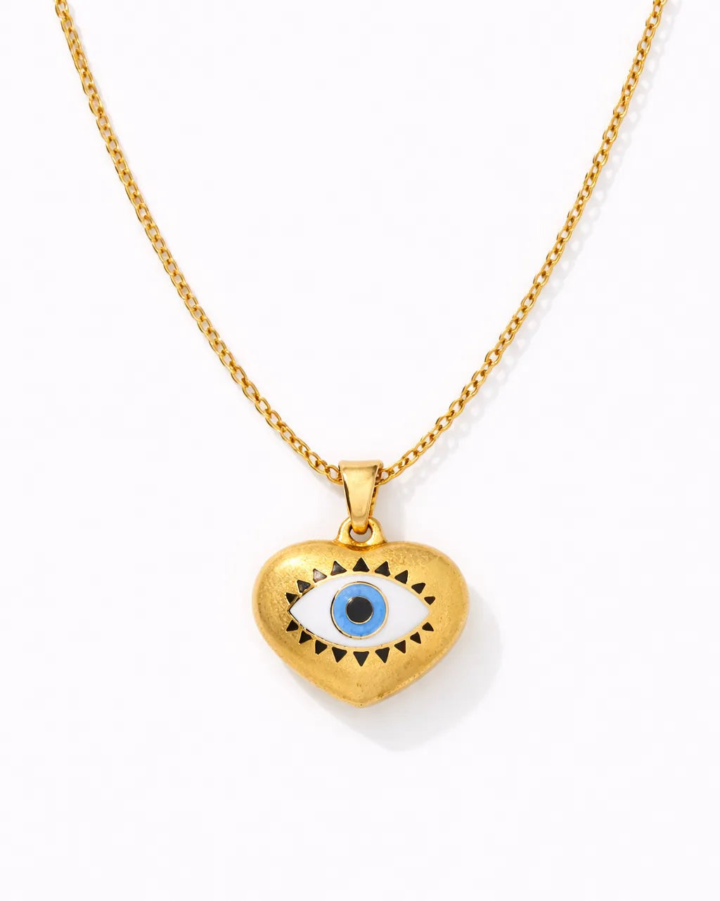 Gold necklace with a heart-shaped pendant featuring an eye design on a white background
