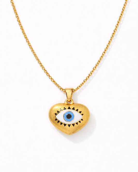 Gold necklace with a heart-shaped pendant featuring an eye design on a white background