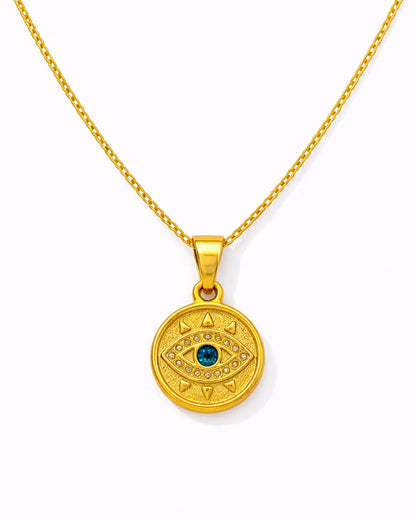 Gold necklace with a round pendant featuring a blue gemstone on a white background