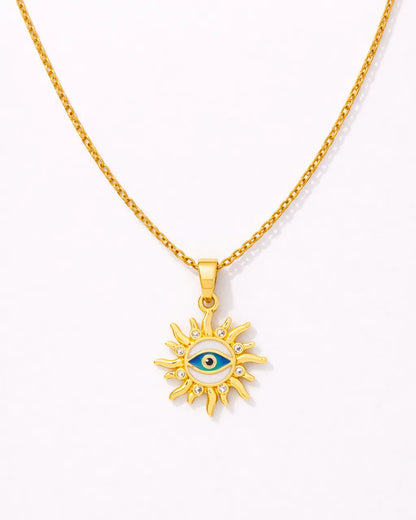 Gold necklace with a sun-shaped pendant featuring an eye design on a white background