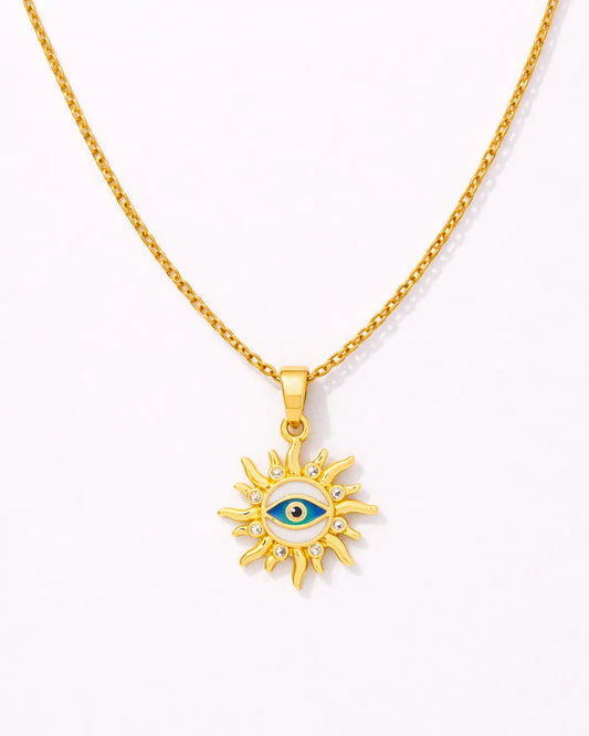 Gold necklace with a sun-shaped pendant featuring an eye design on a white background