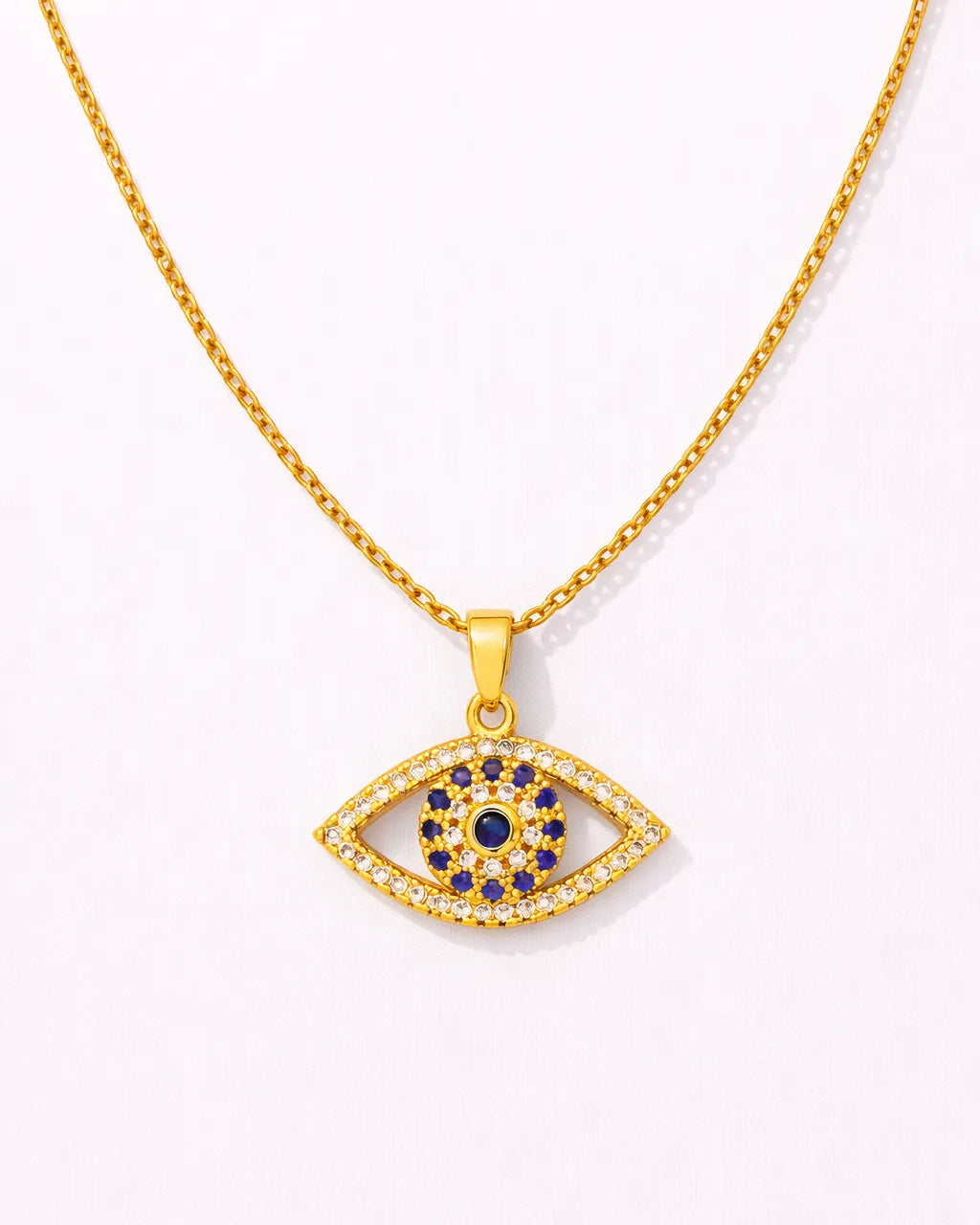 Gold necklace with an eye-shaped pendant featuring blue stones on a white background