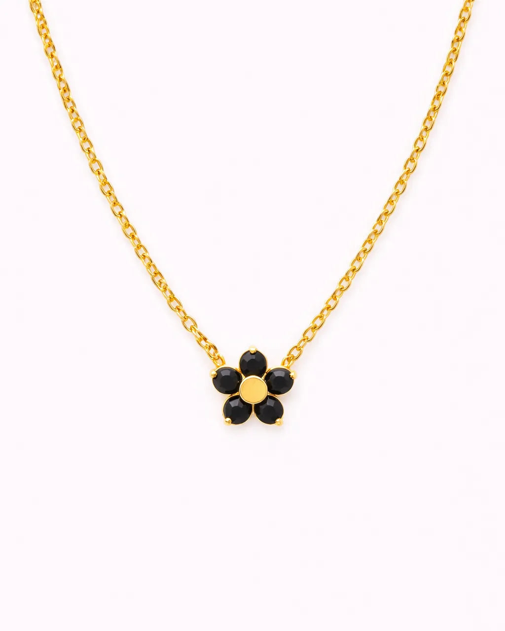 Gold necklace with a black flower pendant on a white background