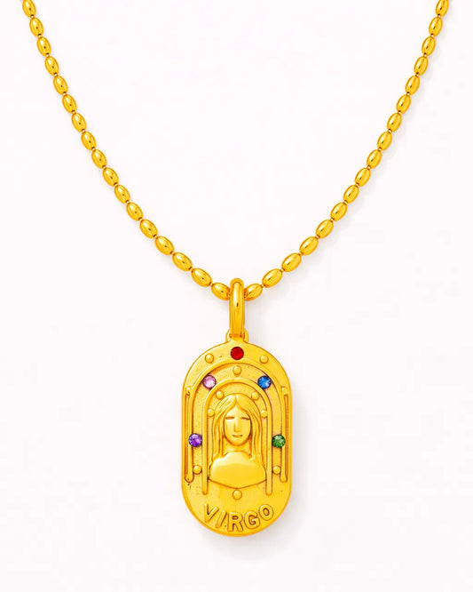 Gold pendant with colorful stones on a white background