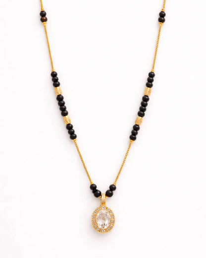 Necklace with black beads and a gold pendant on a white background