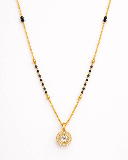 Gold necklace with a round pendant on a white background