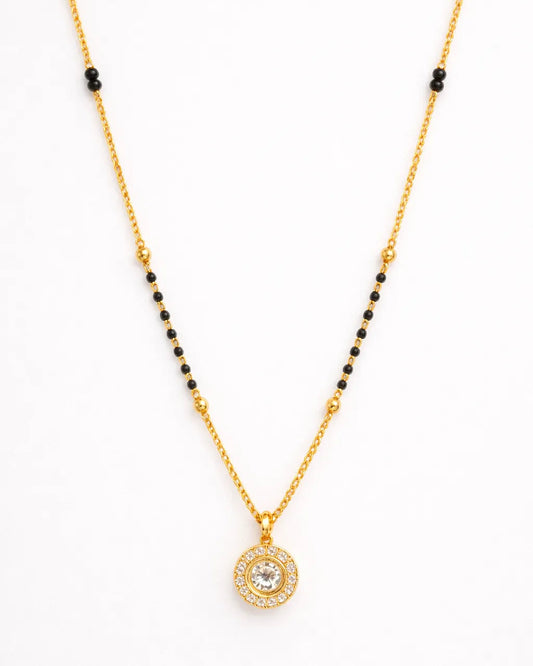 Gold necklace with a round pendant on a white background