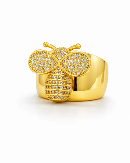 Gold butterfly-shaped ring with gemstones on a white background