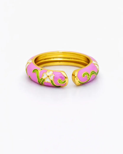 Pink and gold ring with floral design on a white background