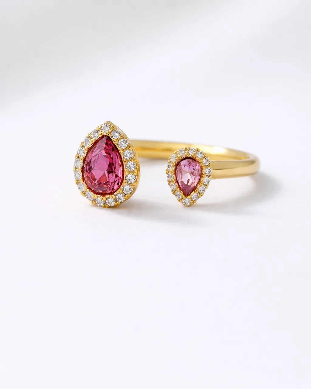 Gold ring with pink gemstones on a white background