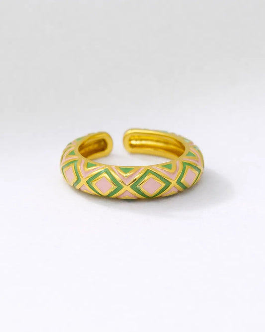 Gold bracelet with green and pink geometric pattern on a white background