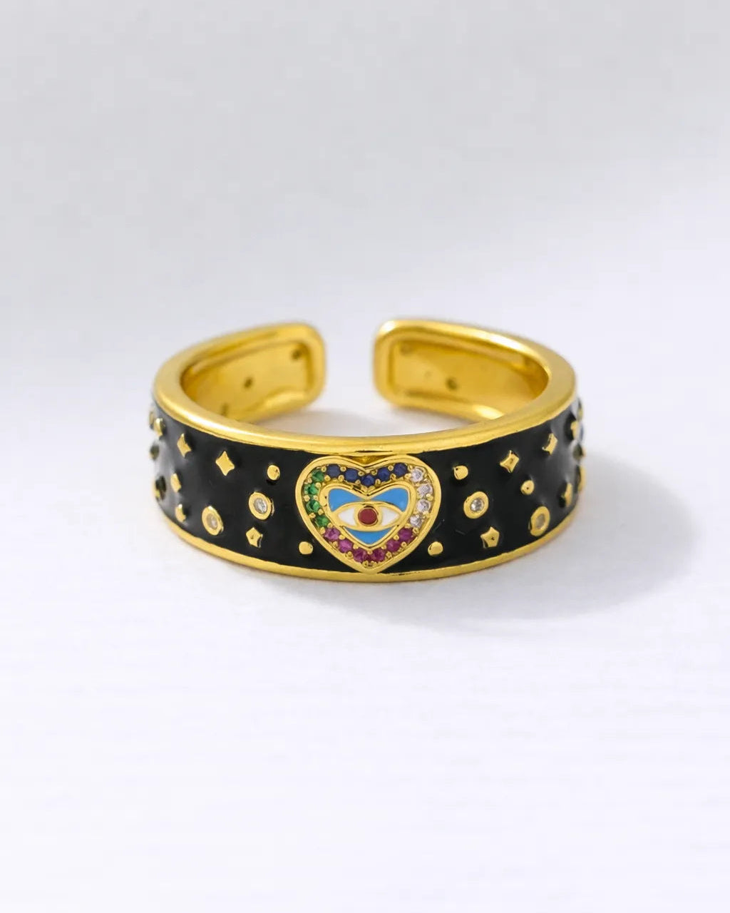 Gold and black cuff bracelet with a heart-shaped emblem on a white background