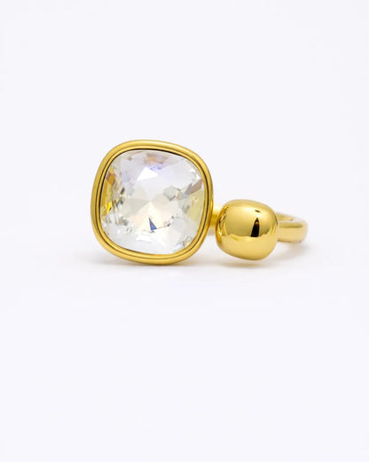 Gold ring with a clear gemstone on a white background