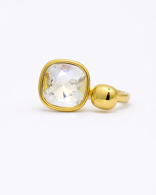 Gold ring with a clear gemstone on a white background