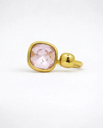 Gold ring with a pink gemstone on a white background