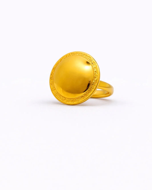 Gold ring with decorative design on a white background