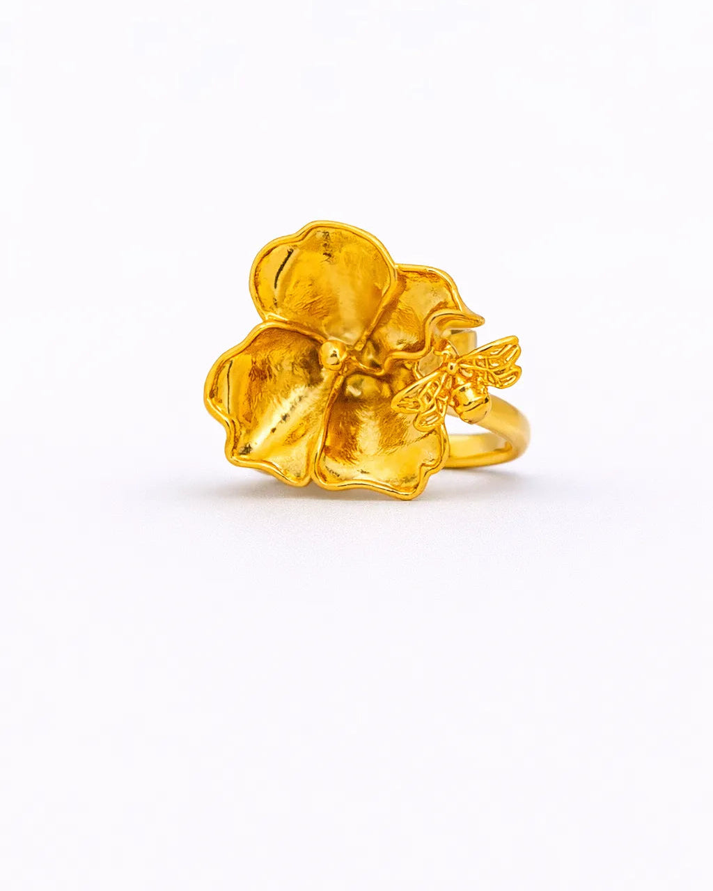 Gold ring with a floral design on a white background