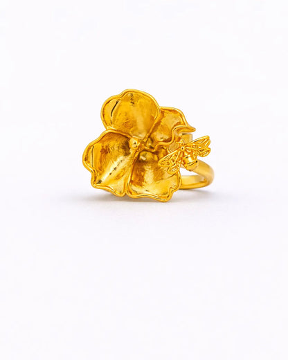 Gold ring with a floral design on a white background