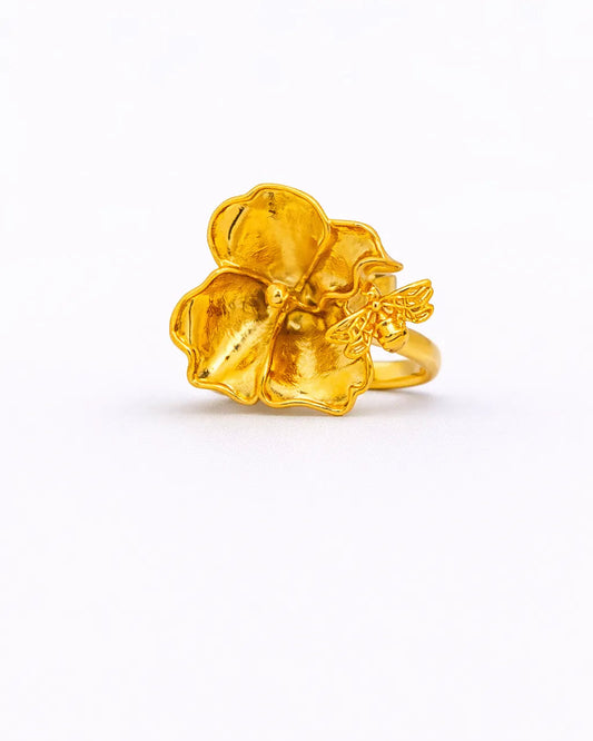 Gold ring with a floral design on a white background