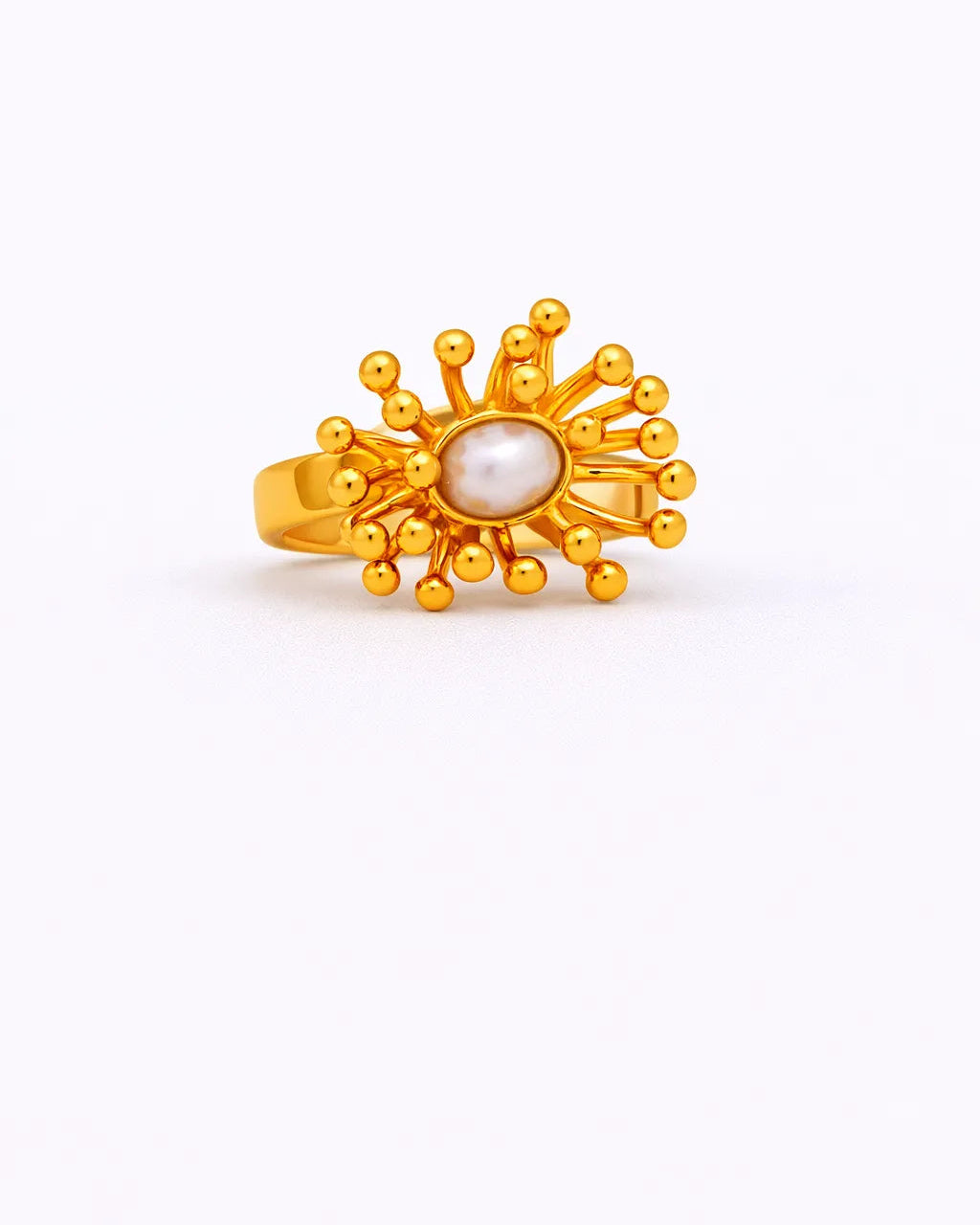 Gold ring with a central pearl on a white background