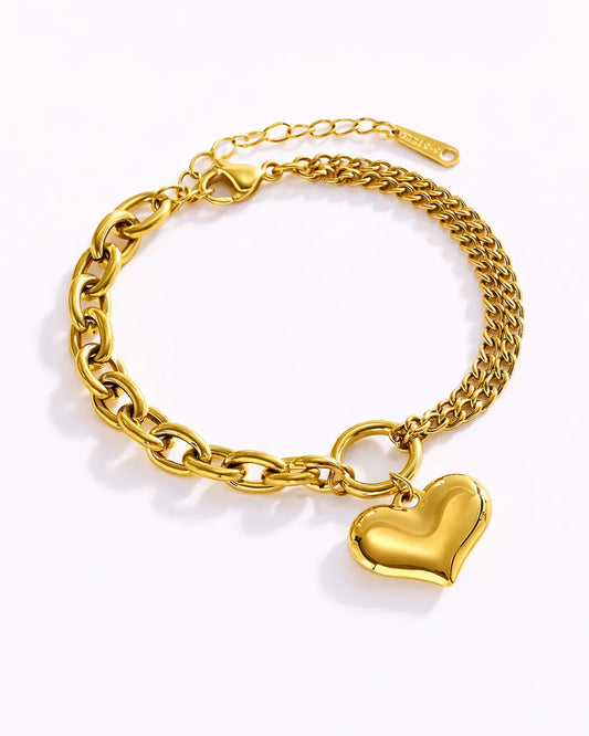 Gold chain bracelet with a heart charm on a white background