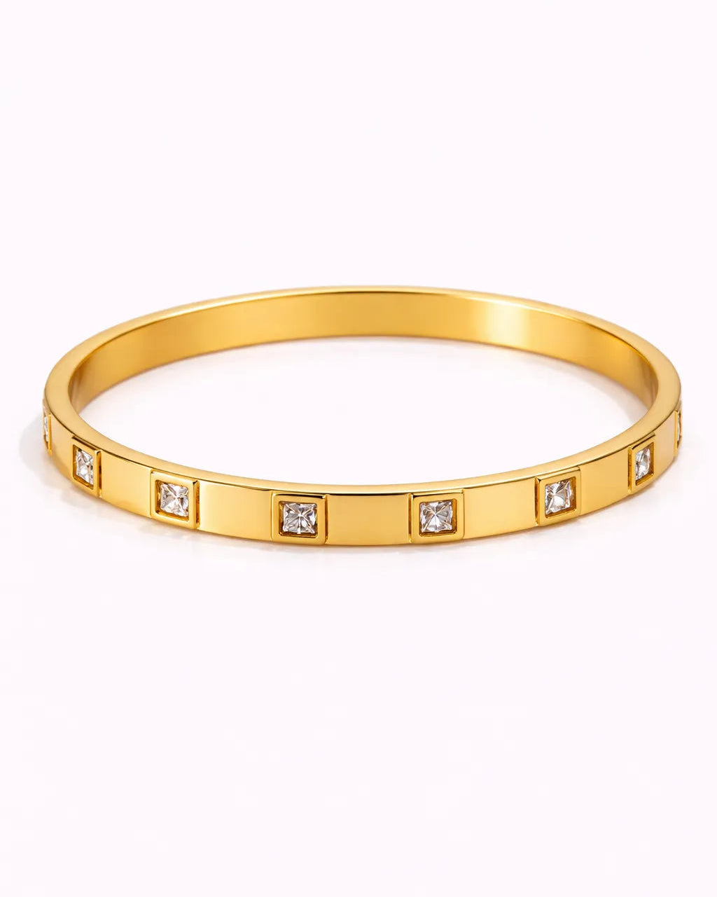 Gold bracelet with embedded diamonds on a white background