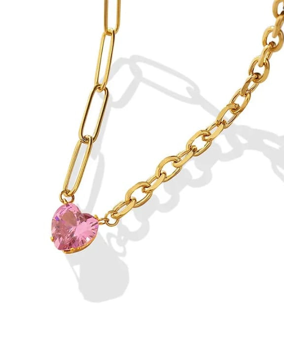 Gold chain necklace with a pink heart-shaped pendant on a white background