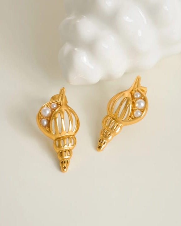 Gold shell-shaped earrings with pearl accents on a white background
